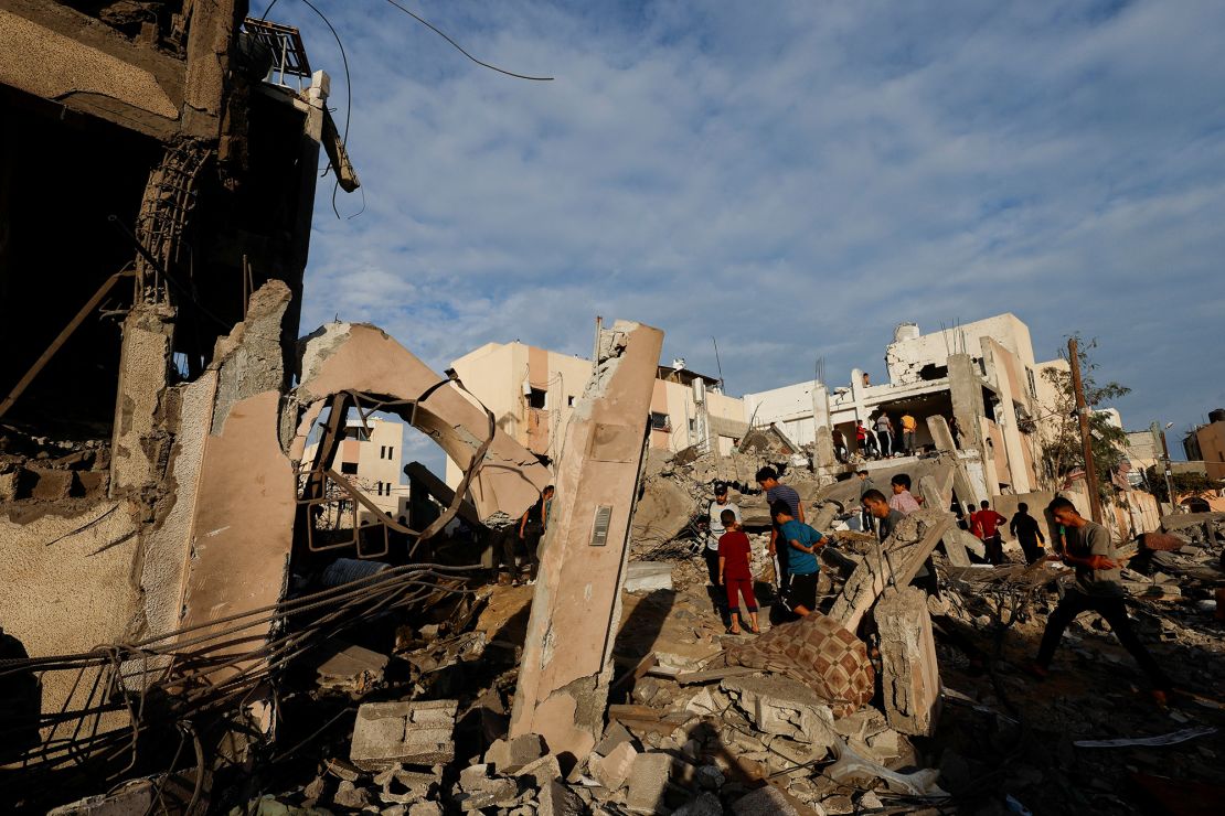 Palestinians search under the rubble of a building destroyed by Israeli strikes in Khan Younis in the southern Gaza Strip, October 17, 2023. 